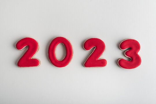 Inscription in red numbers 2022 from gingerbread on white background. Happy New Year 2022