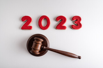 Red lettering 2023 and judges gavel or hammer on white background. Court case in New Year