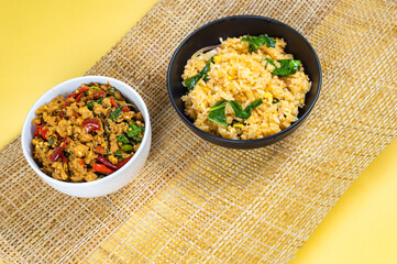 Top-view of Fried Rice in black bowl and Stir-fried basil with minced pork hot and spicy taste serving together,Thai famous food, Hot and spicy food concept, Combo set for eatting.  