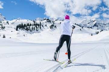 Sportliche junge Frau beim Skilanglauf  in der klassischen Technik