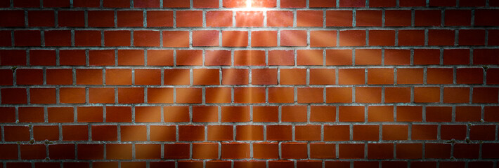 Eine Wand aus roten Steinen mit hellen Licht Strahlen eines Scheinwerfers als Hintergrund