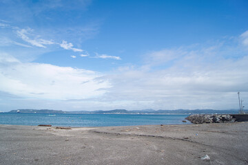 海を眺めて流木に腰を下ろす