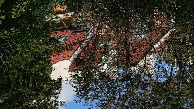 Reflection of the house in the water surface of the pond.