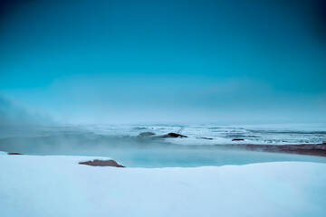 Geothermal winter landscape with snow and fog in iceland