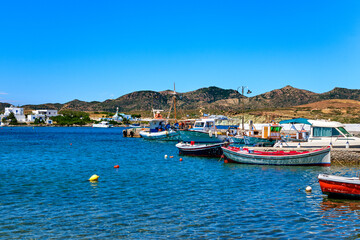Fototapeta na wymiar Beautiful summer day on Greek island, Milos, Greece. Fishing boats at