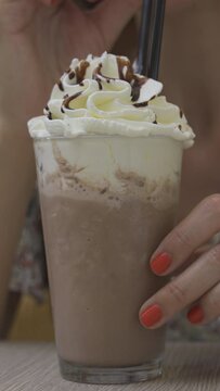 chocolate frappe or frapuccino with woman hand stirring iced. Vertical video