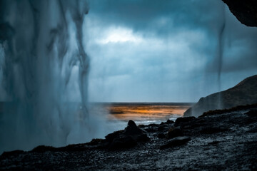 Inside a waterfall with cloudy weather in Iceland 