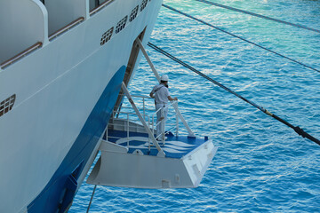 Ship's officer standing on the mooring platform to oversee the safety of berthing of a cruise liner,