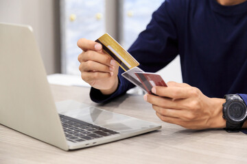 Fototapeta premium Businessman holding credit card for online shopping bill on smartphone, positive man shopping online remote payment , smart payment concept individual bank
