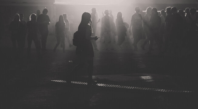 silhouettes of people walking at sunset festival