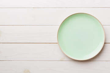 Top view of empty green plate on wooden background. Empty space for your design