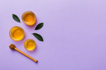 Honey jar with wooden honey dipper on white background top view with copy space. Delicious honey bottle