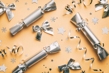 Christmas crackers with shiny confetti on color background, top view, copy space