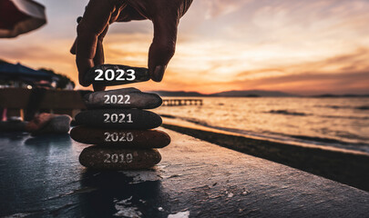Happy new year 2023 replace old 2022. New Year 2023 is coming concept idea on orange sky. High resolution creative photo image can be used as large display, print, website banner, social media post.