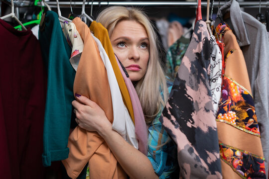 A Dreamy Young Blonde Woman Shopping In A Clothing Store.