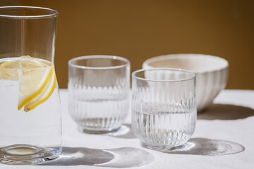 jug with lemon water and glass on table