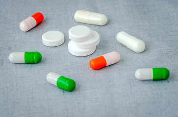 Medication: capsules and pills on a gray background. Medical concept. Close-up
