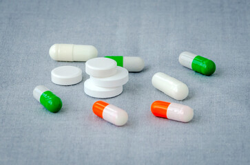 Medication: capsules and pills on a gray background. Medical concept. Close-up