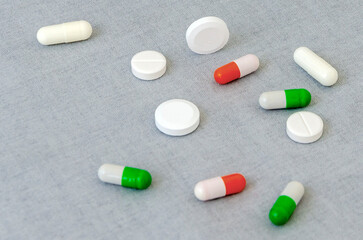 Medication: capsules and pills on a gray background. Medical concept. Close-up