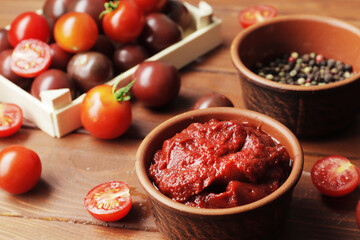 Bowl full of tomato sauce, Wooden spoon full of tomato sauce, spices, seasonings,  Procurement of ingredients for recipes.