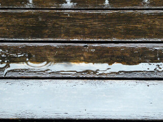 Regentropfen auf nassem Holzboden