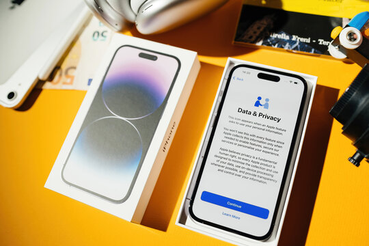 Paris, France - Sep 17, 2022: Cardboard package box unboxing of new Apple Computers iPhone 14 Pro smartphone telephone with data and privacy text confirmation menu during intial setup