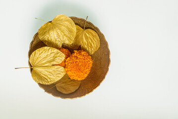 Symbolic golden leaves with marigold flowers in the bowl for the Dussehra occasion. Objects for Hindu festival &lsquo;Vijayadashami&rsquo; or &lsquo;Dashahara&rsquo; celebration.