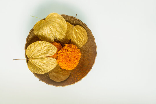 Symbolic golden leaves with marigold flowers in the bowl for the Dussehra occasion. Objects for Hindu festival &lsquo;Vijayadashami&rsquo; or &lsquo;Dashahara&rsquo; celebration.