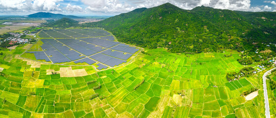 Rice fields interspersed with solar power fields in the morning, a combination of agriculture and energy industry in the border region of Vietnam