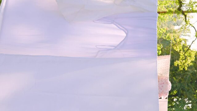 washed white cloth dries on rope