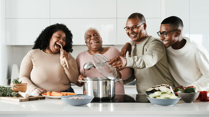 Happy Hispanic family having fun cooking together in modern kitchen - Food and parents unity concept