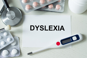 DYSLEXIA word on card on the table next to it is a thermometer, stethoscope and tablets