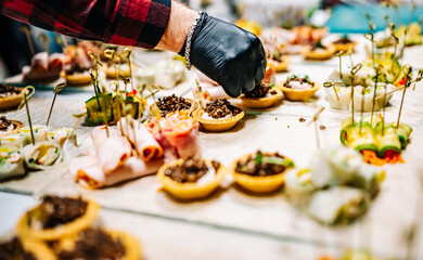 Chef hand is in process of Preparing catering food on table