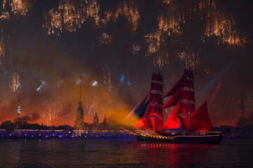 Firework above a boat with scarlet sails on water surface against the Peter and Paul Fortress at...