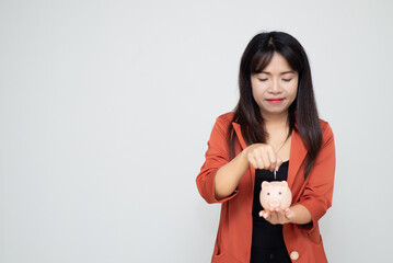 business woman hold piggy bank and putting coin with concrete wall for financial and saving money concept with concrete background and blank copy space.