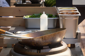 Street food stall with deep wok on oven