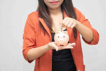 business woman hold piggy bank and putting coin with concrete wall for financial and saving money concept with concrete background and blank copy space.