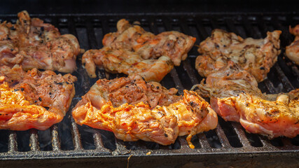 Chicken pieces are cooked on the grill of a street fast food restaurant. Close-up