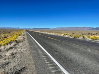 Highway 50 on a sunny day with mountains in the background. Known as the loneliest road in America.