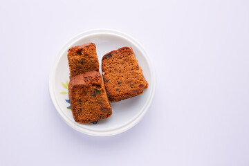 Woman serving homemade Christmas plum cake in white background India Kerala. Fruitcake of dried fruit, nuts, spices , rum New Year party, Easter, Christmas Eve. Indian Christmas celebration