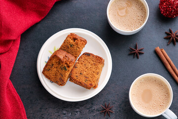 Woman serving homemade Christmas plum cake in black background India Kerala. Fruitcake of dried fruit, nuts, spices , rum New Year party, Easter, Christmas Eve. Indian Christmas celebration