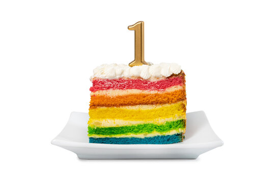 Piece of rainbow cake with the number 1st candle for a birthday