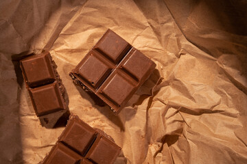 Chocolate bar pieces on kraft paper. - 533134940