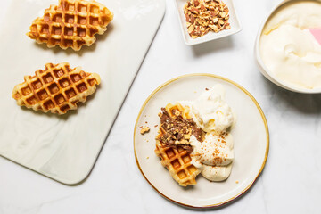 Croffle served with ice-cream, soft whipped cream, chocolate sauce and almond crushed on plate. (Croffle is croissant and waffle). Mix and match menu.