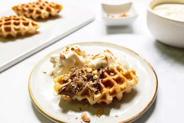 Croffle served with ice-cream, soft whipped cream, chocolate sauce and almond crushed on plate. (Croffle is croissant and waffle). Mix and match menu.