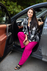 Beautiful modern young woman in her car. The driver automobile. Vacation trip. Lifestyle