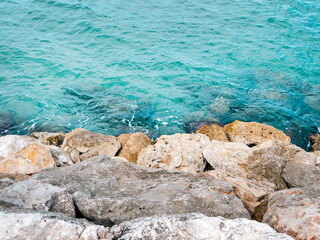 Fototapeta na wymiar Blue sea and grey rocks. Photo from above