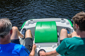 Zwei Männer entspannen bei einer Fahrt mit dem Tretboot