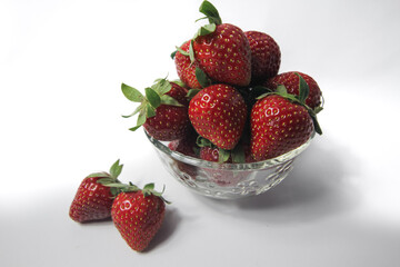 Fresh strawberries in a transparent glass bowl