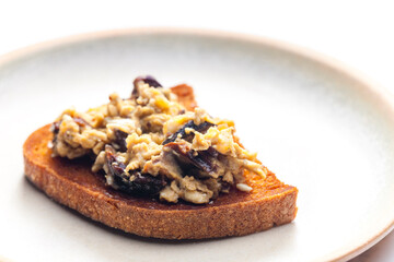 roasted bread served with scrambled eggs and mushrooms